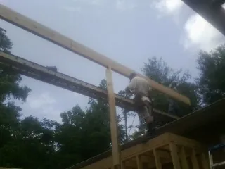Carpenter setting a ridge beam over a new addition frame — Ice Dam Removal by Roofing Brothers in Samaria