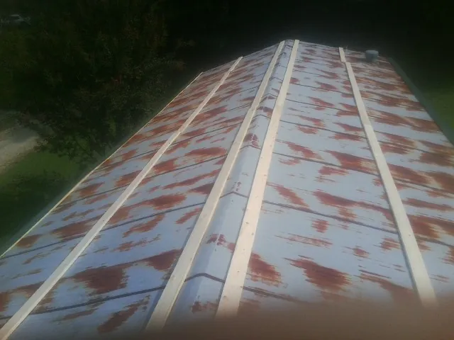 Rusted metal roof panels with new wood purlins before replacement — Storm Damage Roof Repair in Samaria by Roofing Brothers