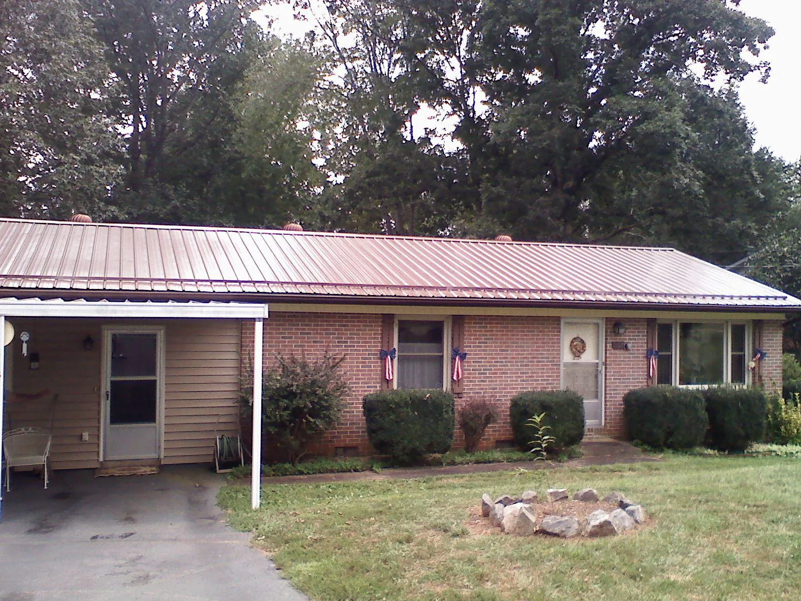 Bronze metal roof and carport on a brick ranch home — Roof Repair work by our crew in Samaria